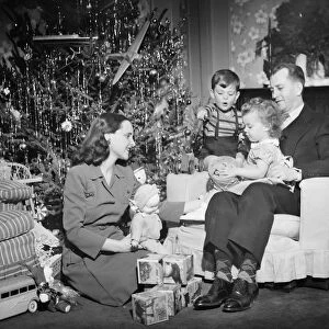 Family opening Christmas presents, children (2-3) (4-5), (B&W)
