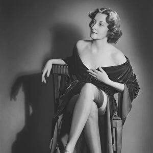 Fashionable woman posing in studio, showing legs, (B&W), portrait