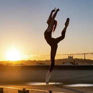 Female ballet dancer dancing on a rooftop at sunset in Lyon with pointes shoes and bodysuit