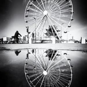 Ferris wheel and its reflection in a puddle, Tours, France Ferris wheel and its reflection in a puddle, Tours, France