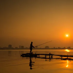 Fisherman fishing on Hanoi West Lake on sunset, Vietnam