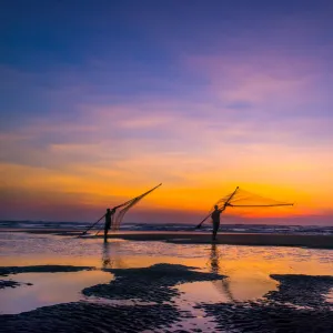 Two Fisherman going on the beach at dawn in Vietnam