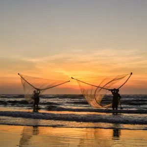 Two Fishermen fishing on the beach at dawn in Vietnam Two Fishermen fishing on the beach at dawn in Vietnam