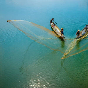 Fishermen throw fishing net on boats to catch fish in Hue, Vietnam