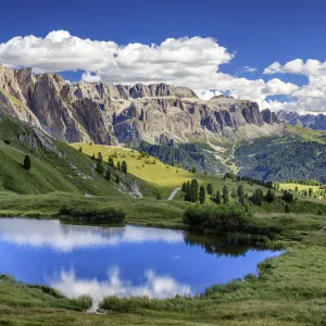 Gardena valley reflecting in a pond on Seceda mountain