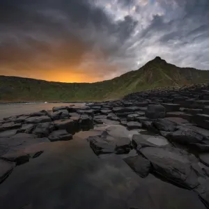 Giants Causeway with colorful sunrise looking towards the cliffs Giants Causeway with colorful sunrise looking towards the cliffs