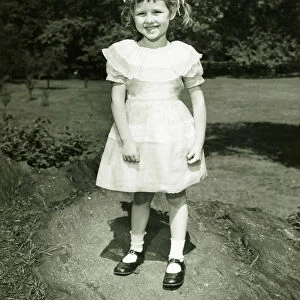 Girl (6-7) in white dress posing in park, (B&W), (Portrait)