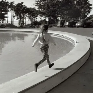 Girl running along edge of fountain Girl running along edge of fountain