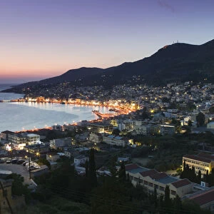 Greece, Samos, Vathy, harbour illuminated at dusk, elevated view