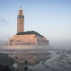 Hassan II Mosque at morning fog reflected on wetland along coastline