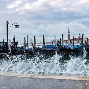 High tide coming on Riva degli Schiavoni, with moored gondolas, Venice, Italy