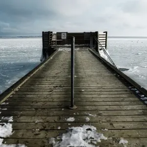 Hole in the ice for winter bathing by a jetty Hole in the ice for winter bathing by a jetty