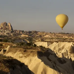 Hot air balloon flying over rock landscape at Cappadocia Turkey Hot air balloon flying over rock landscape at Cappadocia Turkey