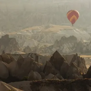 Hot air balloon flying over rock landscape at Cappadocia Turkey Hot air balloon flying over rock landscape at Cappadocia Turkey