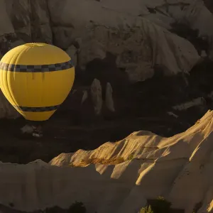 Hot air balloon flying over rock landscape at Cappadocia Turkey Hot air balloon flying over rock landscape at Cappadocia Turkey
