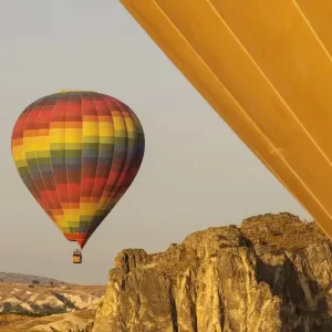 Hot air balloon flying over rock landscape at Cappadocia Turkey Hot air balloon flying over rock landscape at Cappadocia Turkey