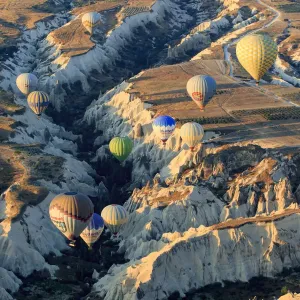 Hot air balloons flying above rock formations in Red Valley, Goreme National Park, Goreme, Cappadocia, Anatolia, Turkey Hot air balloons flying above rock formations in Red Valley, Goreme National Park, Goreme, Cappadocia, Anatolia, Turkey