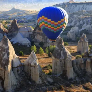 Hot air balloons flying above rock formations in Red Valley, Goreme National Park, Goreme, Cappadocia, Anatolia, Turkey Hot air balloons flying above rock formations in Red Valley, Goreme National Park, Goreme, Cappadocia, Anatolia, Turkey