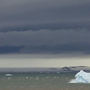 Iceberg floating in Palanderbukta fjord during strong winds and storm clouds, Nordaustlandet, Svalbard Archipelago, Svalbard and Jan Mayen, Norway