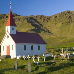 Iceland, church and graveyard in mountainous landscape Iceland, church and graveyard in mountainous landscape
