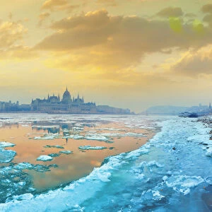 The icy Danube river and the Parliament of Hungary in Budapest at dawn in the winter