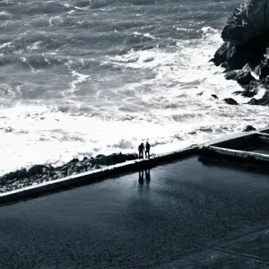 Two individuals meet on a sea wall Two individuals meet on a sea wall