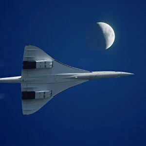 Inflight view of a British Aerospace Concorde SST (Supersonic Transport) with high altitude contrails and the moon