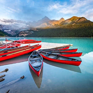 Lake Louise, canoe and kayak on calm water at sunrise. Banff, Canadian Rockies, Canada
