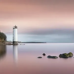 Long exposure of a colourful sunset behind the abandoned lighthouse on the Baltic Sea coast in Maltzien on Ruegen, Germany, Europe Long exposure of a colourful sunset behind the abandoned lighthouse on the Baltic Sea coast in Maltzien on Ruegen, Germany, Europe