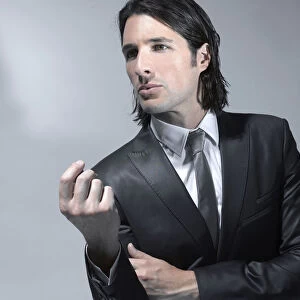 Long-haired man in his early thirties wearing a suit, fashion shoot
