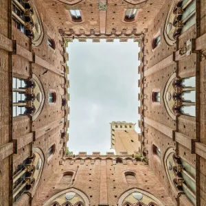 Low angle view of the Torre Del Mangia from Palazzo Pubblico Siena Tuscany