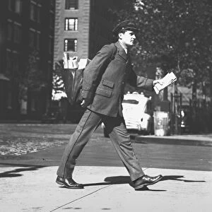 Mailman holding letters walking on street, (B&W)