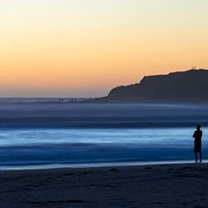 Man on the beach with surf, Opunake, Taranaki Region, New Zealand