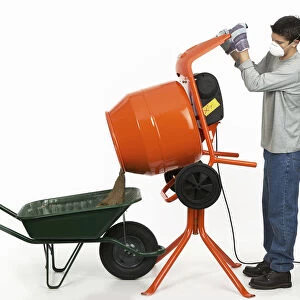 Man emptying contents of cement mixer into a wheelbarrow