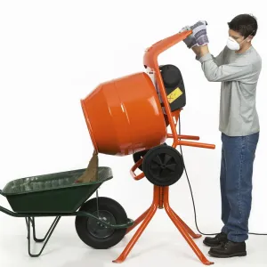 Man emptying contents of cement mixer into a wheelbarrow