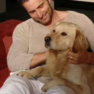 Man with Golden Retriever sitting on a sofa
