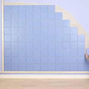 Man placing tile on wall
