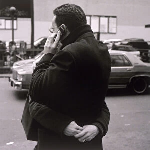 Man talking on cell phone and hugging woman