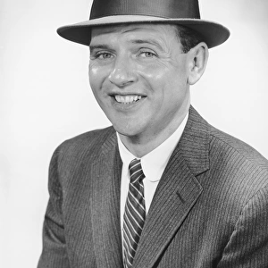 Man wearing hat, posing in studio, (B&W), portrait