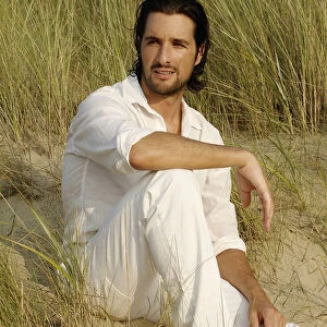 Man wearing white clothes sitting in the dunes