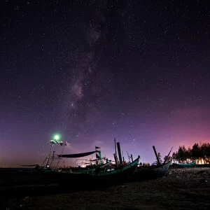 Milky way over fishing boats in beach