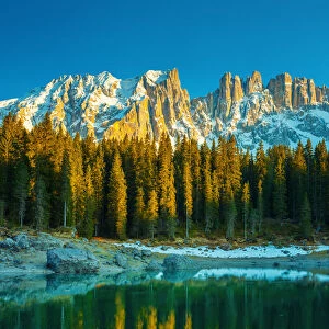 Mountain lake surrounded by pine forest (Carezza Lake in the Latemar mountain range, South Tyrol, Italy)