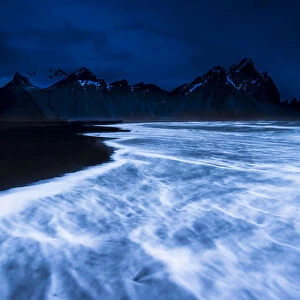 Mountain peaks and surf, blue hour, Hofn, Iceland