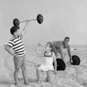 Muscleman and muscleboy on the beach in California, ca. 1958 Muscleman and muscleboy on the beach in California, ca. 1958