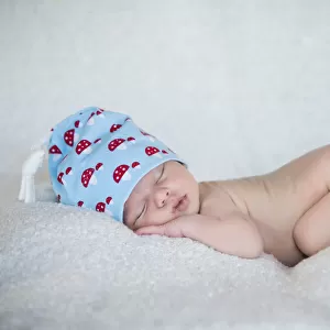 Newborn baby, 3 weeks, sleeping, wearing a hat