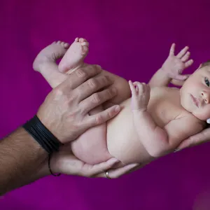 Newborn baby, five days, carried on hands