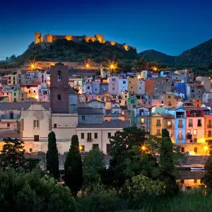 Nighttime view over the colourful town of Bosa and its medieval castle along the Temo