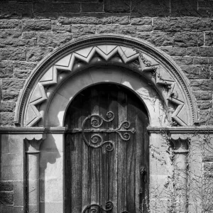 Old church door with stone arch and ornate hinges