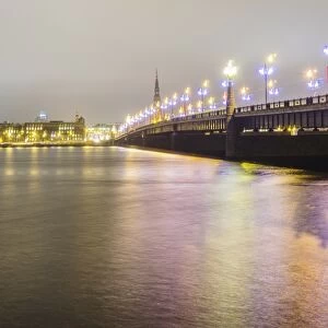 Old Riga skyline at night and Akmens bridge over Daugava river. Riga, Latvia