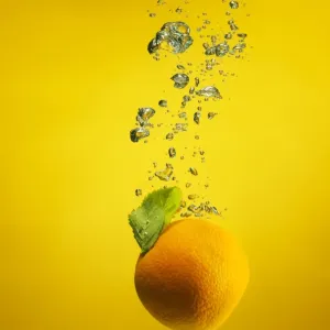 An orange splashed into water An orange splashed into water